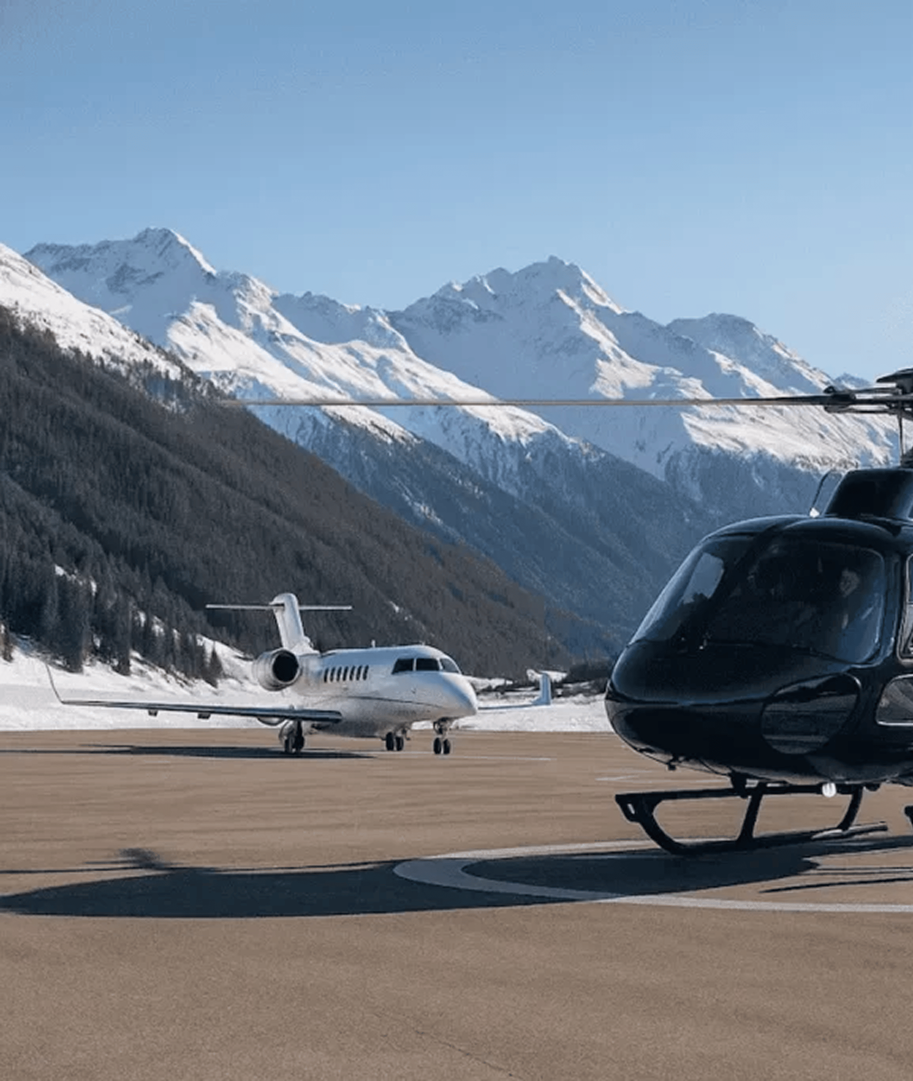 Private jet and helicopter at a mountain airport